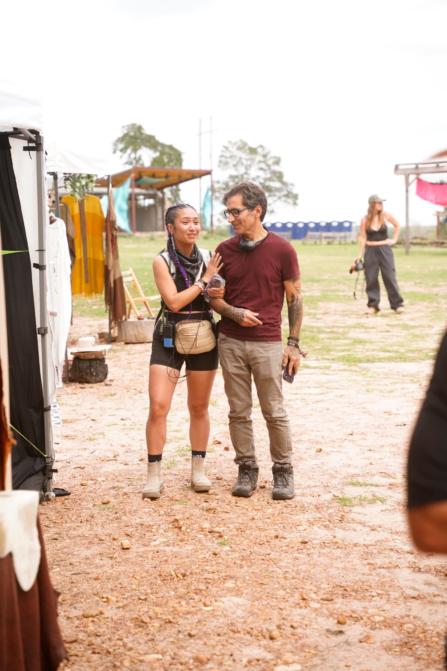 An outdoor festival build, banners raised across an open field